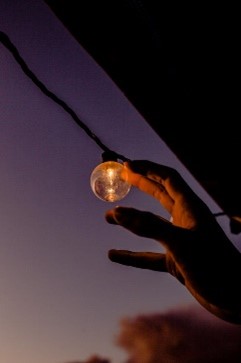 A hand holding a light bulb

Description automatically generated